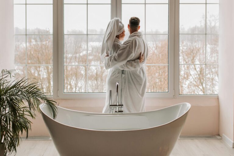 Romantic couple wrapped in towels embracing near a bathtub with a panoramic view – Zennergy’s signature couples spa experience
