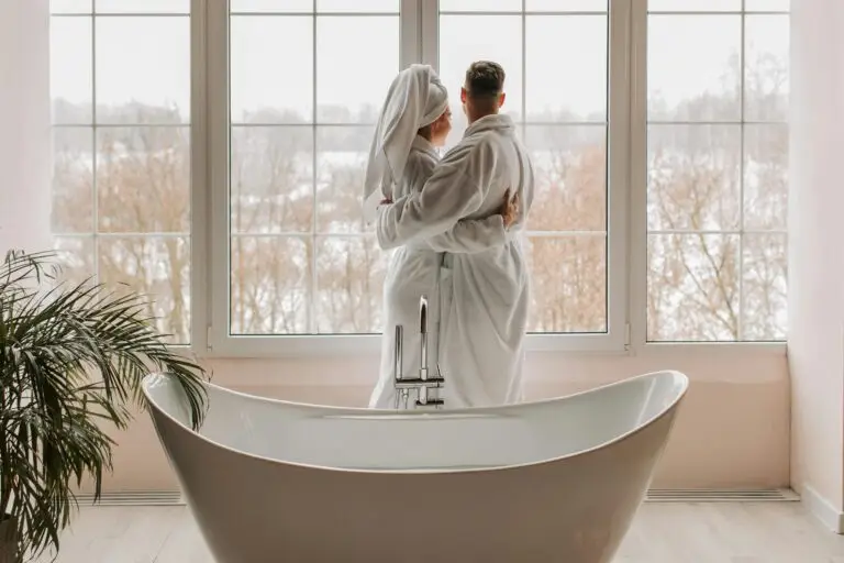 Romantic couple wrapped in towels embracing near a bathtub with a panoramic view – Zennergy’s signature couples spa experience